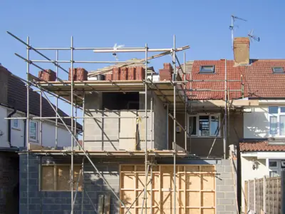 Extension with scaffolding against a blue sky