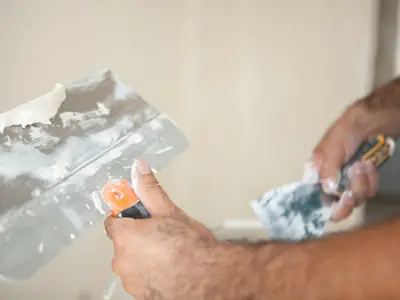 Plastering a wall with trowels